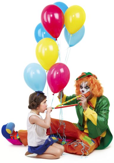 Ein Clown bläst in eine Pfeife, während ein Mädchen mit bunten Luftballons sitzt.