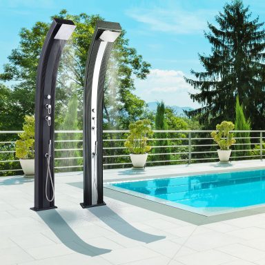 Zwei elegante Duschen neben einem Pool in einer sonnigen Umgebung mit Bäumen im Hintergrund.
