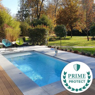 Ein moderner Pool mit Holzterrasse, umgeben von grüner Landschaft und herbstlichen Bäumen.